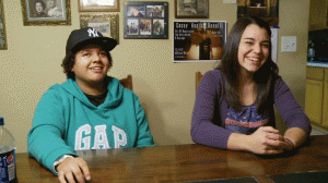 Dani and Athena look near the camera, smiling and laughing at the dining room table.