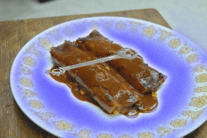 Two mole enchiladas with a wrench on a glowing purple plate.