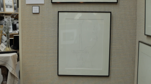 Framed pen and ink drawing of Multnomah Falls in a thin black frame on the wall.