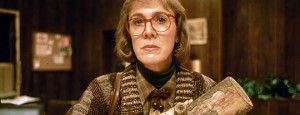 [A close up of The Log Lady, cradling her log, looks intently at the camera and listens closely.