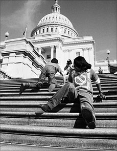 Image of three people crawling up US Capitol building. Main person in photo is a young black woman crawling up backward. Image from "Lives Worth Living" movie.