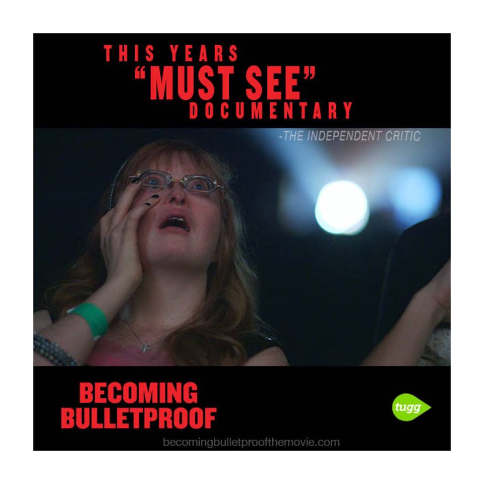 Elizabeth McCurry in a theater, proudly watching herself onscreen. Text reads: "This year's 'must see' documentary"-The Independent Critic.]