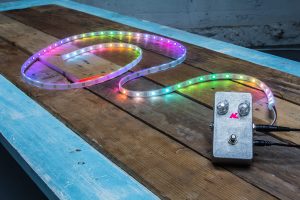 AudioLux one: a small silver box connected to a flexible strip covered in small, colored lights.